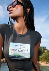 Sivý krátky rukáv tričko s obdĺžnikovou grafikou a textom "Posledná, posledná šanca!" a ilustráciou vintage auta.