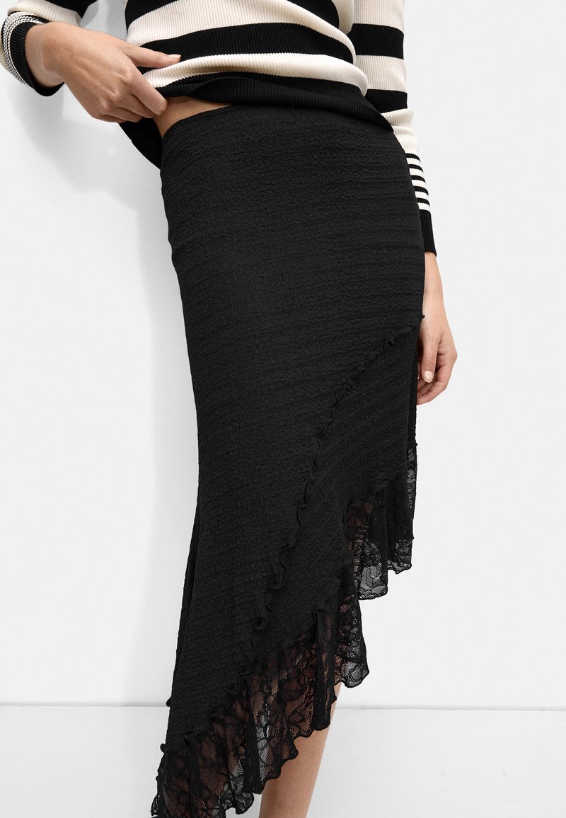 Czarna midi spódnica z teksturowanej tkaniny, z koronkowym wykończeniem u dołu oraz falbaną dla dodatkowego efektu.