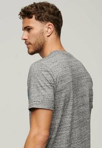 Gray melange short-sleeve t-shirt with a round neckline, soft texture, and subtle horizontal pattern. Fits close to the body.