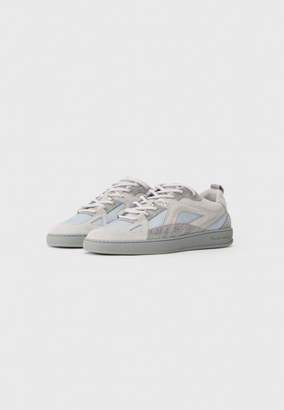 Baskets en nubuck et en maille de couleur bleu clair et gris, avec un design basse, semelle en caoutchouc et accents réfléchissants. Lacets épais blancs.