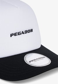 Weißes Cap mit schwarzem Schirm, mit gesticktem "PEGADOR"-Logo auf der Vorderseite und einem runden Etikett auf dem Schirm. Material ist Stoff mit glatter Textur.