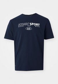 T-shirt de manga curta azul-marinho, feito de algodão, com texto branco: "ICONIC SPORT READY SET MOVE" e um logótipo ao centro.