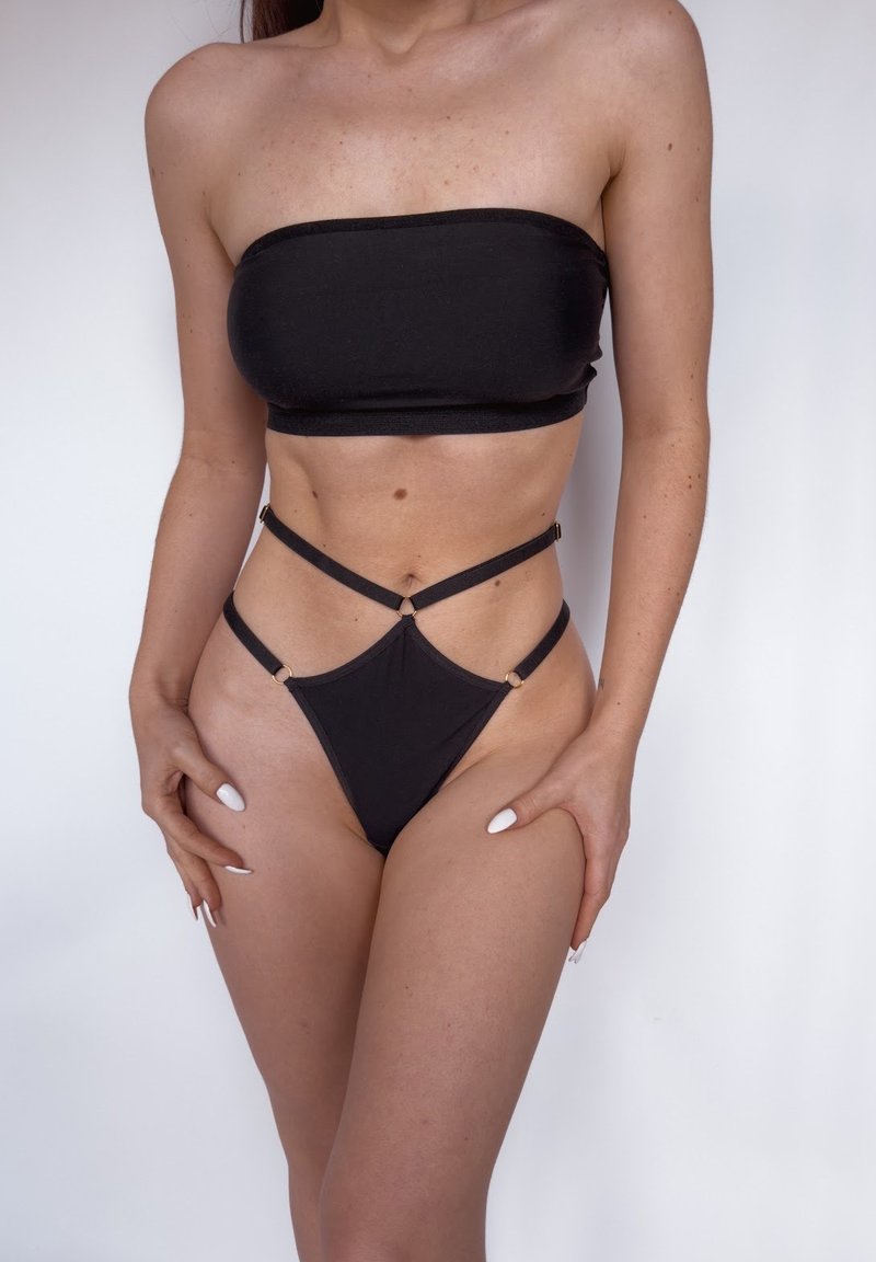 Schwarzes Bandeau-Top mit einer figurbetonten Passform, kombiniert mit einem hoch geschnittenen Tanga mit Kreuzträgern und goldenen Hardware-Akzenten.