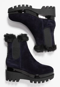 Granatowe zamszowe botki za kostkę z futrzanym obszyciem, elastycznymi bokami oraz masywną czarną platformą z ząbkowanym wzorem.
