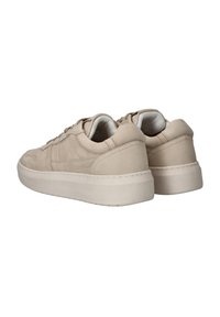 Beige suède sneakers met een ronde neus, platte veters en een verhoogde rubberen zool. Geweven details aan de zijkanten en zichtbare stiksels.