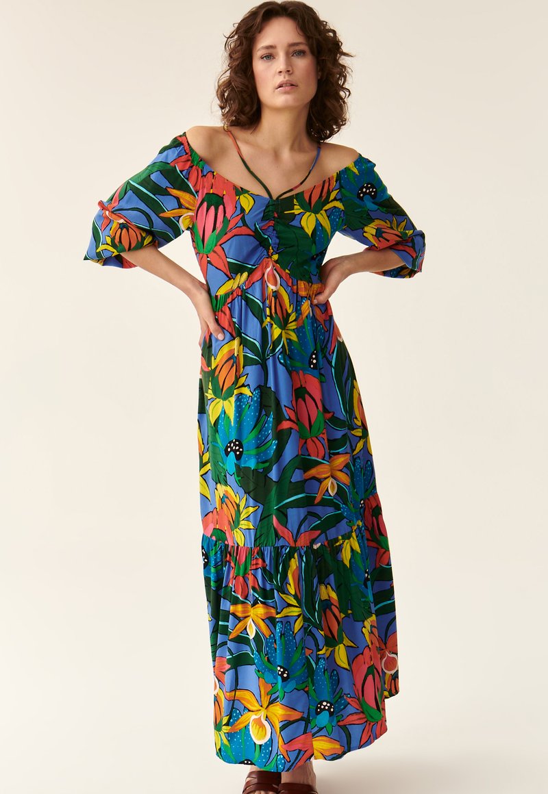 Maxikleid in leuchtend blauem Blumenmuster mit schulterfreien Ärmeln, Rüschensaum und Bindegürtel. Enthält lebhafte Blumen in Rot, Gelb und Grün.