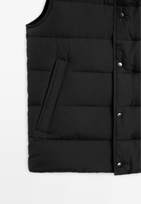 Gilet puffo nero con design trapuntato, bottoni a pressione e tasca laterale. Il materiale appare liscio con una finitura opaca.