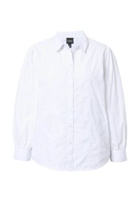 Camisa blanca de botones con cuello, mangas largas abullonadas y un sutil bordado de corazones en la tela. Material de algodón suave y texturizado.