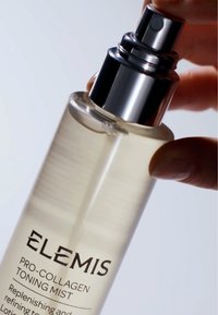 Klar glassprayflaske med sølvpumpe. Inneholder en lys gul toningsmist. Merkingen leser "ELEMIS PRO-COLLAGEN TONING MIST."