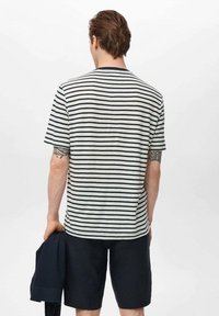 Striped t-shirt in light gray and navy blue, made of soft fabric. Short sleeves with a round neck. Worn with navy shorts.