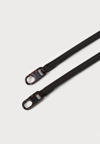 Zwarte faux leren band met contrasterende rode stiksels, voorzien van metalen clips aan beide uiteinden voor bevestiging. Glad oppervlak en rechthoekige vorm.