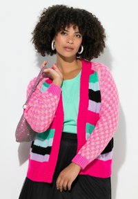 Kleurrijke gebreide cardigan met roze, groene en zwarte patronen, met een losse pasvorm, ribbels aan de randen en gestructureerde mouwen.