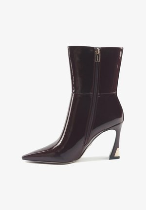 Burgundy patent leather ankle boot with a pointed toe and a mid-heel. Features a side zipper and contrasting heel detail. Smooth texture.