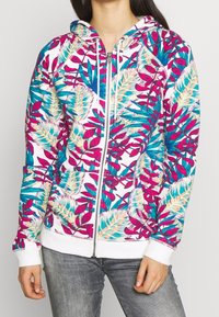 Hooded zip-up sweatshirt featuring a colorful floral pattern in pink, turquoise, and cream on a white background; ribbed cuffs and hem.
