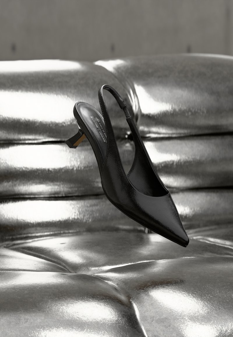 Μαύρο μυτερό παπούτσι slingback με γυαλιστερό δερμάτινο φινίρισμα, με χαμηλό τακούνι τύπου block και λεπτό λουράκι στον αστράγαλο, αιωρούμενο πάνω από μια μεταλλική επιφάνεια.