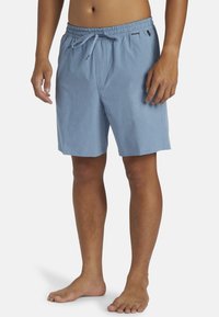 Pantalones cortos de tiro azul claro con cordón, hechos de una tela suave, que presentan un ajuste relajado, bolsillos laterales y una textura lisa. Aptos para uso casual.