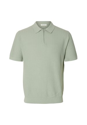 Světle zelené polo tričko s krátkými rukávy a žebrovanou texturou, s límečkem a polovičním zipem vpředu.