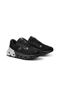 Black athletic shoes with a textile upper, contrasting white midsole, and unique cushioning design featuring cutouts and rubber outsole details.