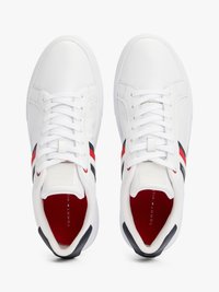 Sneakers atletici bianchi con un esterno in pelle liscia, dotati di strisce rosse e nere sui lati e di una fodera interna rossa.