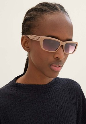 Beige zonnebril met een rechthoekige vorm en gradient roze lenzen. Heeft een gestructureerde matte afwerking en subtiele branding aan de zijkant.