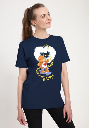Camiseta de color azul marino con un oso de peluche de dibujos animados sobre una patineta, rodeado de nubes y estrellas amarillas. Tela de algodón suave, corte relajado.