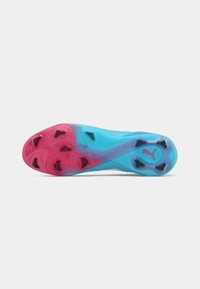 Semelle de crampons de soccer colorée en bleu et rose avec des pointes noires et le logo Puma sur un fond blanc.