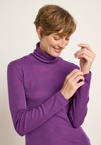 Lila Langarm-Turtleneck-Shirt aus einem weichen, glatten Stoff, mit eng anliegenden Ärmeln und hohem Kragen. Keine sichtbaren Muster oder Verzierungen.
