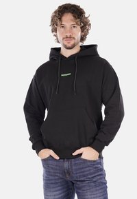 Felpa nera realizzata in tessuto morbido, con tasca a marsupio, cappuccio con cordino e piccolo logo verde "PROPAGANDA" sul petto.