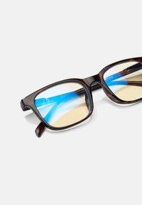 Gafas de forma cuadrada con montura de carey, lentes de tono azul y un acabado brillante. Presentan patrones de colores claros y oscuros.