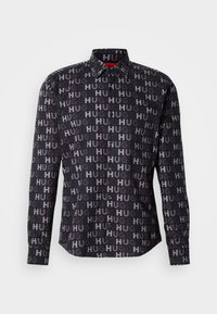 Chemise noire à manches longues avec boutons, ornée d'un motif répété de texte "HUG" dans différentes nuances de gris et dotée d'un col pointu.