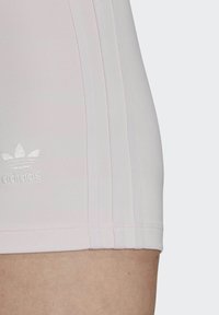 Heledad roosa sportlühikesed püksid, mis on valmistatud venivast kangast, küljepeal on kolm valget triipu ja väike valge adidas logo.