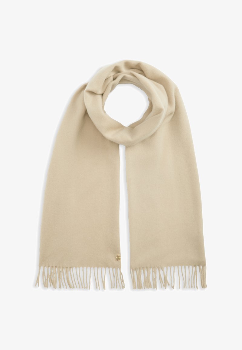 Écharpe beige douce avec des extrémités à franges, joliment bouclée en haut, présentée sur fond blanc.