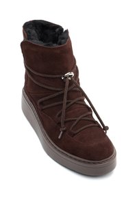 Brūni zamšādas zābaki ar teksturētu apdari, iezīmēti ar biezu zoli, apaļu purngalu un brūnām auklām. Mugurējā daļā redzama mīkstināta iekšpuse.