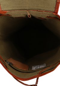 Bolso de cuero color canela con interiores de tela verde, que cuenta con un bolsillo con cremallera y una etiqueta. El interior tiene un acabado suave, diseñado para la practicidad.