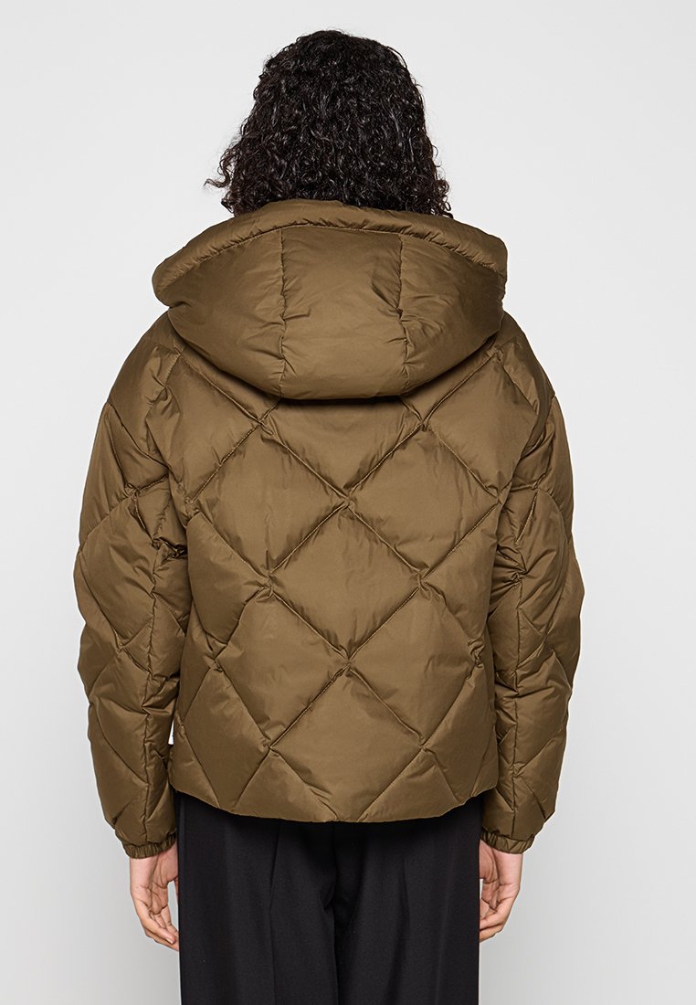 Bruine pufferjack met capuchon, voorzien van een geborduurd ruitpatroon en een soepele textuur. Het ontwerp heeft een ontspannen silhouet en een cropped lengte.