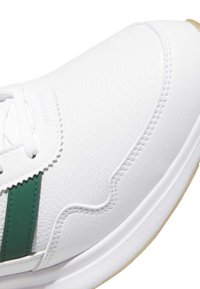 Sneaker in pelle bianca con dettagli verdi, tomaia testurizzata e suola in gomma a contrasto. Dotata di lacci bianchi e dettagli a zigzag lungo il bordo.