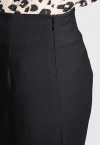 Schwarzer Bleistiftrock mit glatter Textur, seitlichem Reißverschluss und tailliertem Schnitt, minimalistisch gestaltet für Vielseitigkeit.