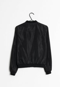 Czarna kurtka bomberka o gładkim satynowym wykończeniu. Posiada ściągacze przy kołnierzu, mankietach i u dołu, luźny krój oraz marszczoną talię.