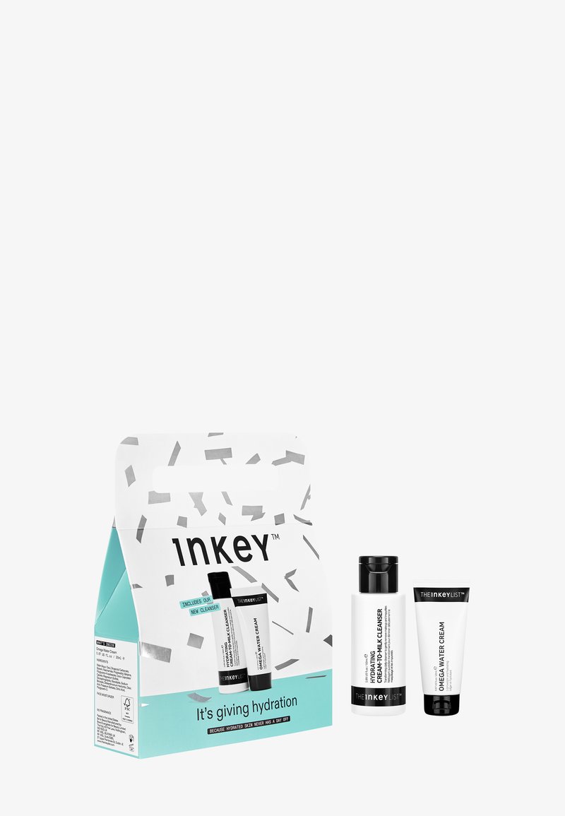 Set di idratazione Inkey con un flacone di detergente bianco e nero e un tubo di crema, esposti in una scatola turchese e bianca con motivo di coriandoli.
