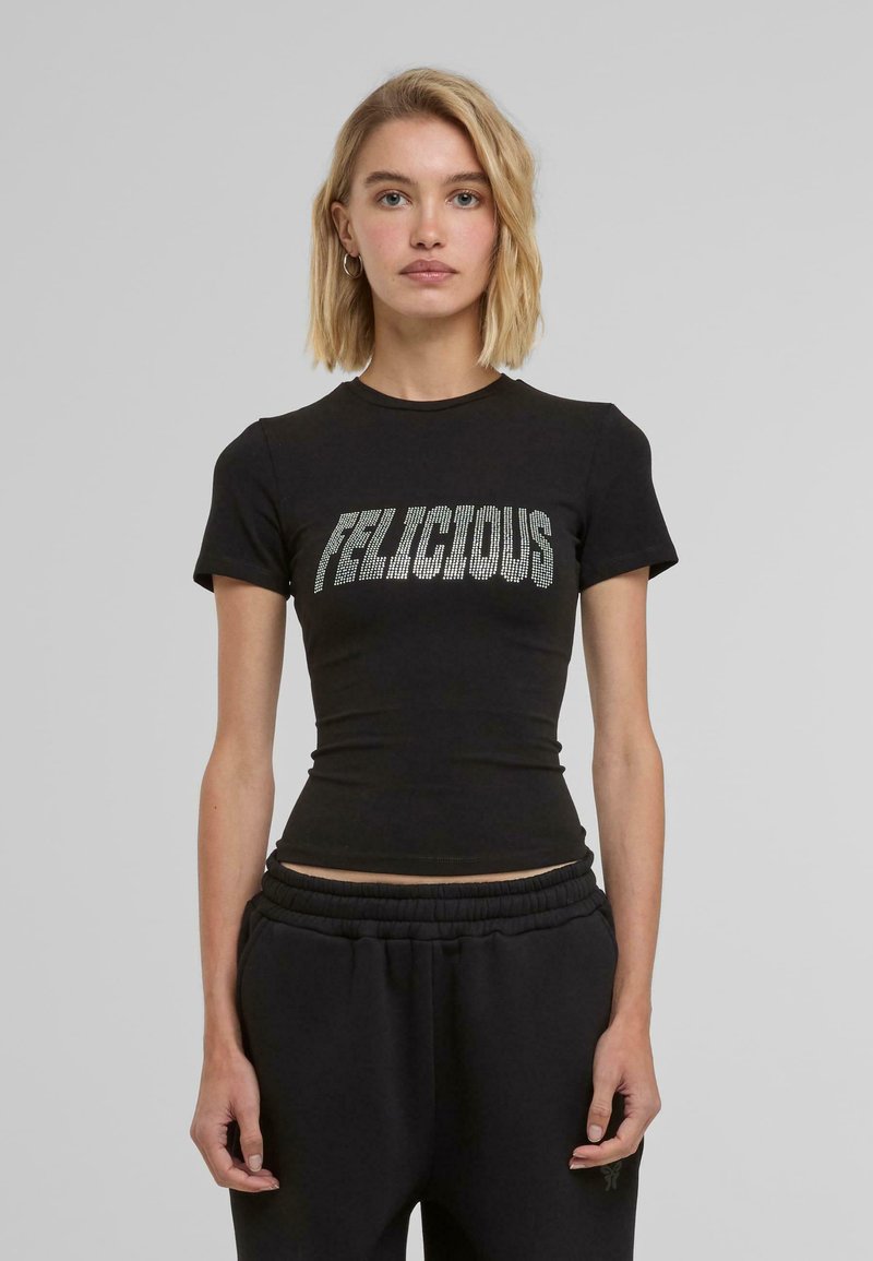 Svart kortärmad t-shirt i bomull med texten "FELICIOUS" i silverstrass över bröstet.