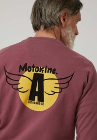 Sudadera burdeos con un gran gráfico en la parte posterior: un círculo amarillo con texto negro "Motors Inc." y una "A" con alas, y "ALTONADOCK."