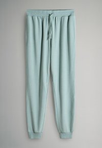 Világoskék, gofrómintás, szabadidő nadrág elasztikus derékpánttal, húzózsinórral és bordázott szegélyekkel, egy szürke felületen kiterítve.