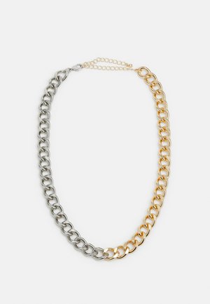 Colar de corrente em tom de prata e dourado, com elos metálicos alternados, um fecho de lagosta e uma extensão de corrente ajustável para variação de tamanho.