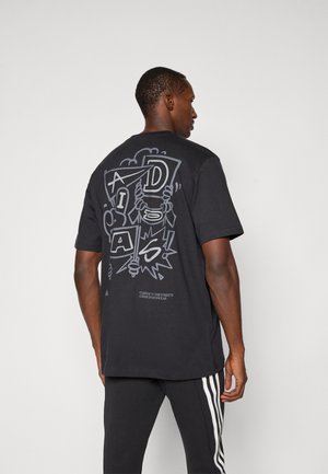 T-shirt nera in cotone con un design grafico sul retro, completo di testo e illustrazioni. Maniche corte, vestibilità rilassata.