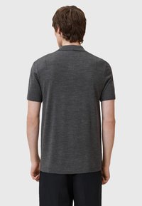 Dunkelgraues Kurzarm-Poloshirt aus weichem Stoff, mit einem klaren Schnitt und dezenten Nahtdetails an den Schultern und im Rücken.