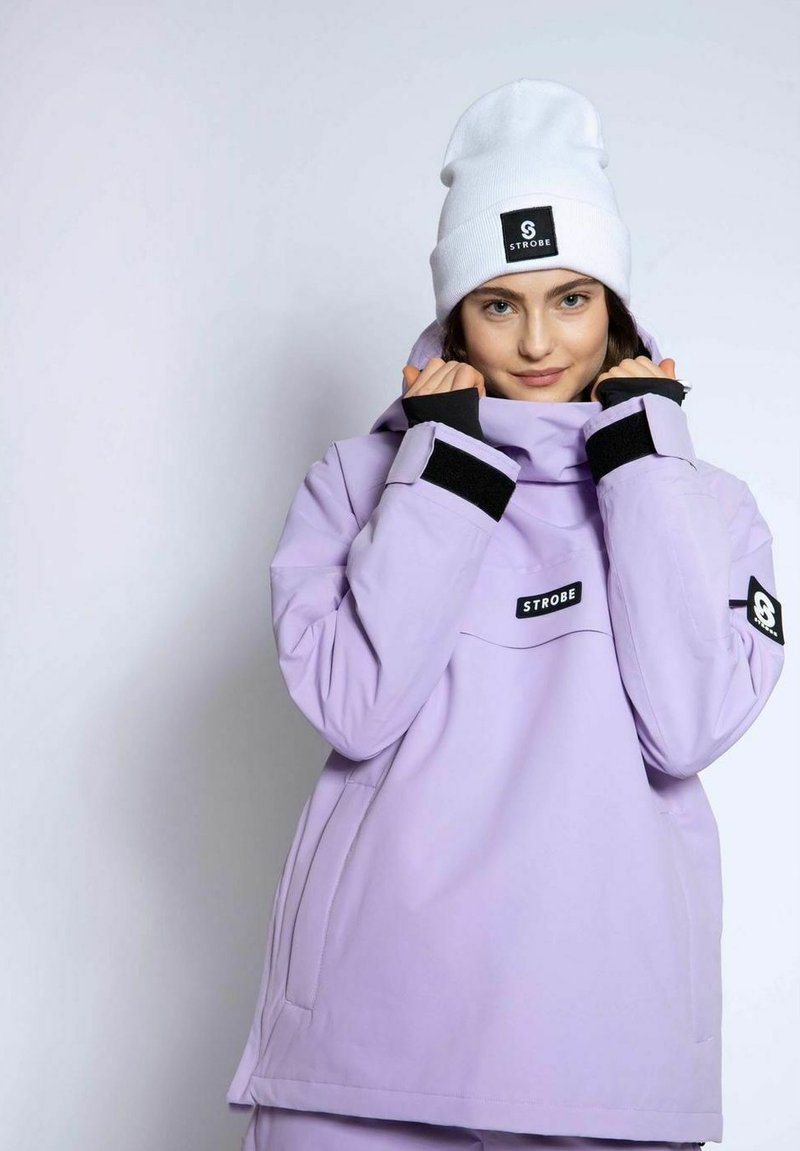 Lilla vandtæt jakke med en struktureret krave, sorte Velcro-ærmer og en frontlomme. Sammen med en hvid hue med et logo-patch.