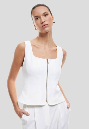 Haut sans manches blanc avec un décolleté carré, doté d'une fermeture éclair à l'avant et d'une coupe structurée, texture lisse et design moderne.