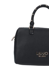 Black leather handbag with structured design, top handle, gold-tone hardware, and embossed logo on the front. Features rivet accents on the handle.