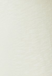 Tkanina bawełniana w kolorze off-white z subtelną teksturą. Materiał ma gładką, jednolitą powierzchnię z lekkim połyskiem.