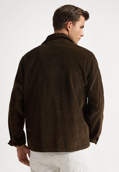 Καφέ ζακετάκι από κορντόρι με γιακά, εμφανή κάθετα ριμπ, μανσέτες με κουμπιά και άνετη εφαρμογή. Η πίσω όψη αναδεικνύει την υφή.